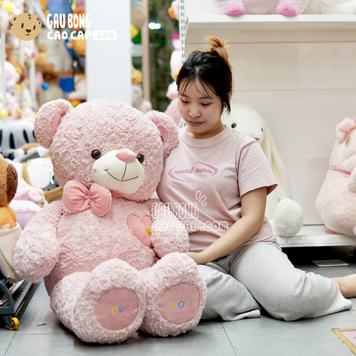 Gấu Bông Teddy Hồng Lông Xoắn Ngực Tim Đeo Nơ